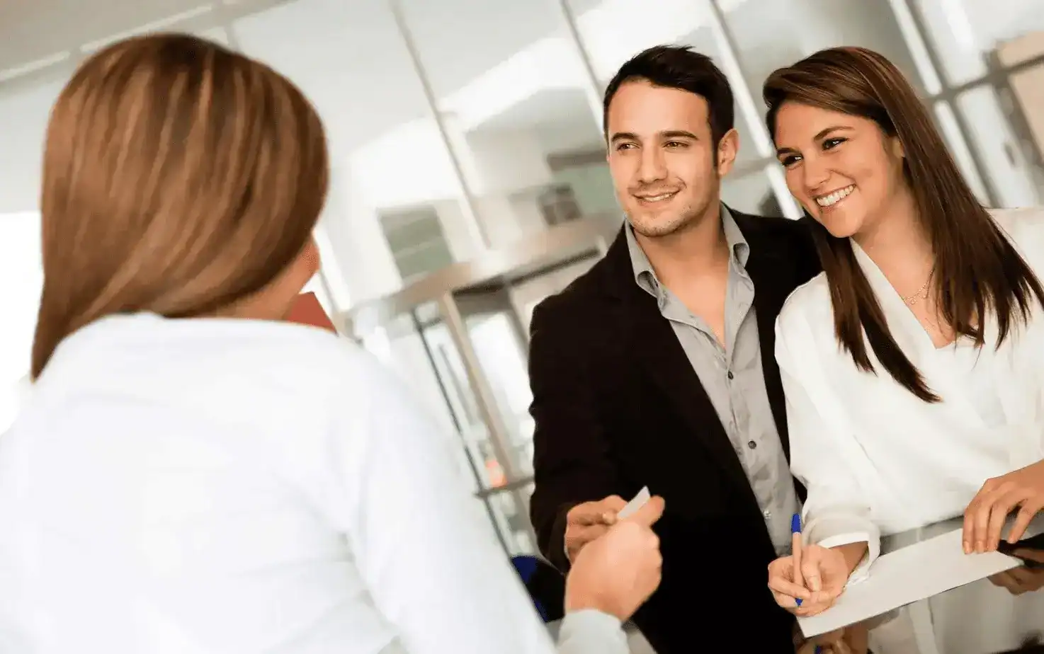 Smiling couple checking in at APX Hotels reception desk, showcasing excellent customer service and guest experience in Sydney accommodation
